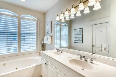 a bathroom with two sinks and a tub and a large mirror at Castle in the Sand by 30A Escapes in Seacrest