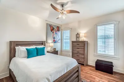 a bedroom with a bed and a ceiling fan at Castle in the Sand by 30A Escapes in Seacrest