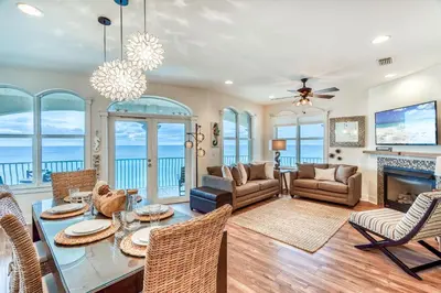a living room with a table and chairs and a fireplace at Castle in the Sand by 30A Escapes in Seacrest