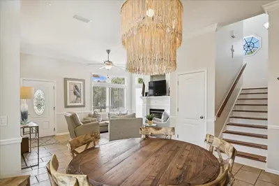 a living room with a wooden table and a chandelier at Shiloh by 30A Escapes in Seacrest