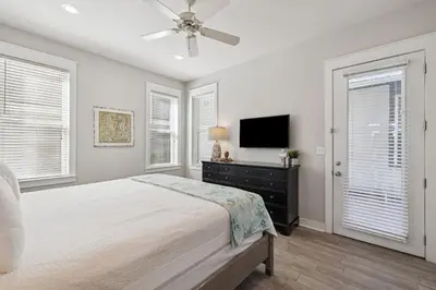 a bedroom with a bed and a flat screen tv at Ocean Pearl by 30A Escapes in Rosemary Beach