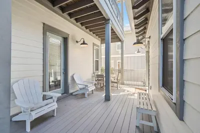 a porch with two chairs and a bench on it at Ocean Pearl by 30A Escapes in Rosemary Beach