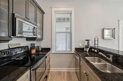 a kitchen with black counter tops and a sink at Ocean Pearl by 30A Escapes in Rosemary Beach