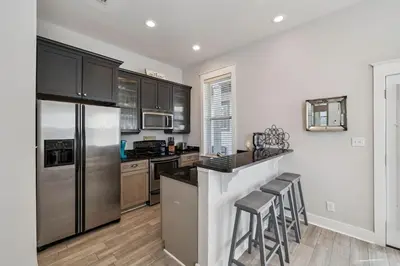a kitchen with stainless steel appliances and black cabinets at Ocean Pearl by 30A Escapes in Rosemary Beach