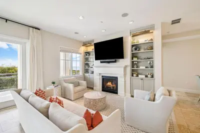 a living room with white furniture and a fireplace at Three Amigos Gulf Front by 30A Escapes in Seagrove Beach