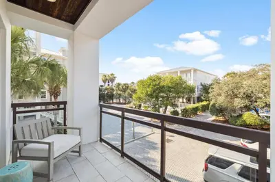 a balcony with a chair and a view of a street at Three Amigos Gulf Front by 30A Escapes in Seagrove Beach