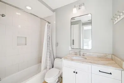 a bathroom with a sink and a toilet and a mirror at Three Amigos Gulf Front by 30A Escapes in Seagrove Beach