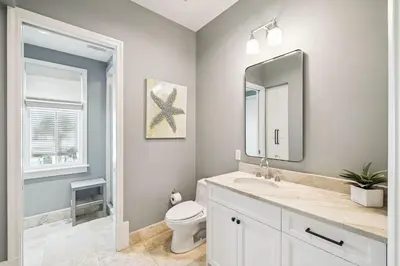 a bathroom with a sink and a toilet and a mirror at Three Amigos Gulf Front by 30A Escapes in Seagrove Beach