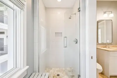 a white bathroom with a shower and a sink at Three Amigos Gulf Front by 30A Escapes in Seagrove Beach