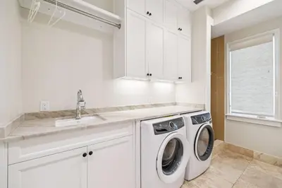 a white kitchen with a washing machine and a sink at Three Amigos Gulf Front by 30A Escapes in Seagrove Beach