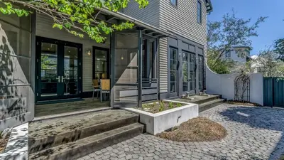 a home with a stone walkway leading to the front door at Timeless by 30A Escapes in Rosemary Beach