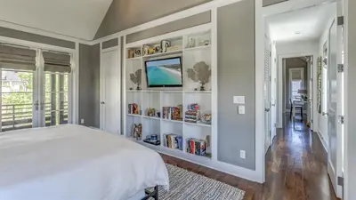 a bedroom with a bed and a book shelf at Timeless by 30A Escapes in Rosemary Beach