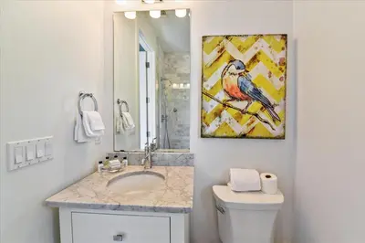 a bathroom with a toilet and a painting on the wall at Timeless by 30A Escapes in Rosemary Beach