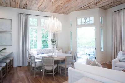 a dining room with a table and a chandelier at Amen Corner by 30A Escapes in Rosemary Beach