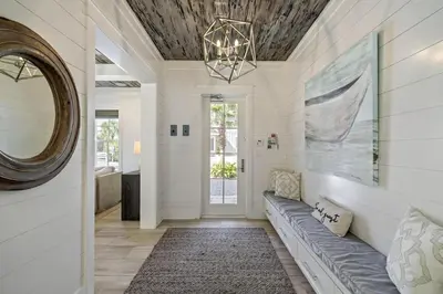 a living room with a couch and a mirror at High Noon by 30A Escapes in Rosemary Beach