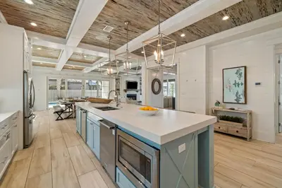 a kitchen with blue cabinets and a white counter top at High Noon by 30A Escapes in Rosemary Beach