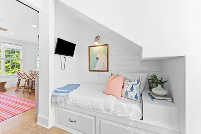 a white room with a bed with pillows on it at Sands Cottage Carriage by 30A Escapes in Rosemary Beach