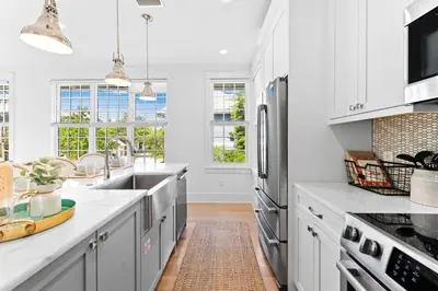 a kitchen with white cabinets and a sink at Sands Cottage Carriage by 30A Escapes in Rosemary Beach