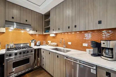a kitchen with stainless steel appliances and wooden cabinets at Ocean`s Six by 30A Escapes in Rosemary Beach