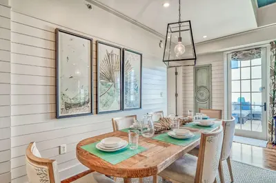 a dining room with a wooden table and chairs at 6 Barrett Place by 30A Escapes in Rosemary Beach