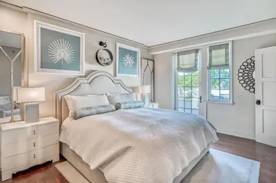 a bedroom with a white bed and windows at 6 Barrett Place by 30A Escapes in Rosemary Beach