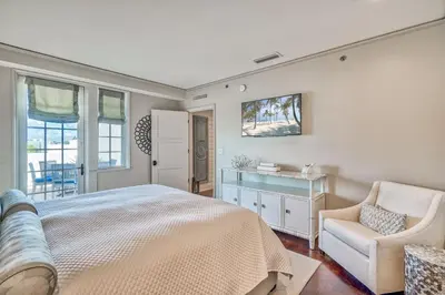 a bedroom with a bed and a chair at 6 Barrett Place by 30A Escapes in Rosemary Beach