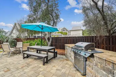 a patio with a table and an umbrella and a grill at All In - Seacrest by 30A Escapes in Seacrest