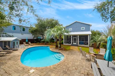 a backyard with a swimming pool and a house at All In - Seacrest by 30A Escapes in Seacrest