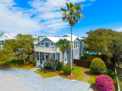 a palm tree in front of a house at All In - Seacrest by 30A Escapes in Seacrest
