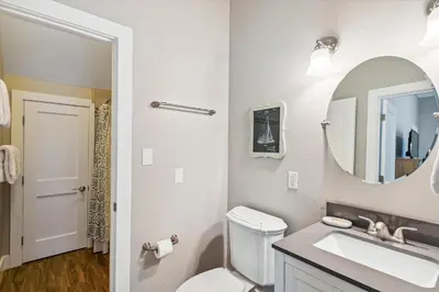 a white bathroom with a sink and a mirror at All In - Seacrest by 30A Escapes in Seacrest
