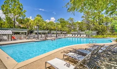 a swimming pool with lounge chairs in a resort at Moon Landing by 30A Escapes in Watersound Beach
