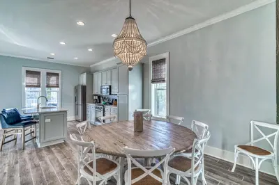 a kitchen and dining room with a wooden table and chairs at As Good as it Gets by 30A Escapes in Rosemary Beach