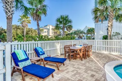 a patio with chairs and a table and a pool at As Good as it Gets by 30A Escapes in Rosemary Beach