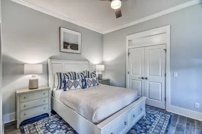 a bedroom with a bed and a dresser and a lamp at As Good as it Gets by 30A Escapes in Rosemary Beach