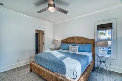 a bedroom with a blue bed and a window at As Good as it Gets by 30A Escapes in Rosemary Beach