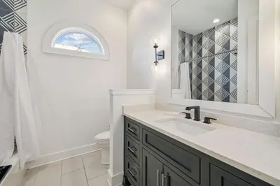 a bathroom with a sink and a toilet and a mirror at Sea Star by 30A Escapes in Seacrest