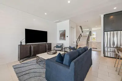 a living room with a blue couch and a tv at Sea Star by 30A Escapes in Seacrest