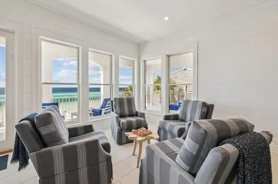 a living room with three chairs and windows at Sea Star by 30A Escapes in Seacrest