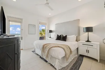 a white bedroom with a large bed and a window at Sea Star by 30A Escapes in Seacrest