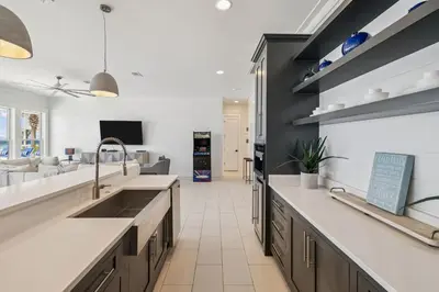 a kitchen with a sink and a living room at Sea Star by 30A Escapes in Seacrest