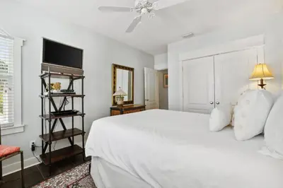 a white bedroom with a bed and a tv at Sunset Beach 202B by 30A Escapes in Rosemary Beach