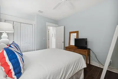 a white bedroom with a bed and a television at Sunset Beach 202B by 30A Escapes in Rosemary Beach