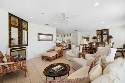 a living room with white furniture and a fireplace at Sunset Beach 202B by 30A Escapes in Rosemary Beach