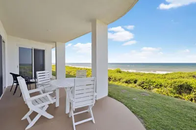 a porch with a table and chairs and the ocean at HP 16E Beach Treat by 30A Escapes in Rosemary Beach