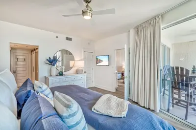 a bedroom with a blue bed and a balcony at HP 15W Salt and Light by 30A Escapes in Rosemary Beach