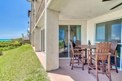 a patio with a table and chairs and the ocean at HP 15W Salt and Light by 30A Escapes in Rosemary Beach