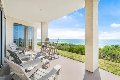 a patio with chairs and tables looking out at the ocean at HP 16W Seadawg by 30A Escapes in Rosemary Beach