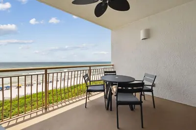 a balcony with a table and chairs and the beach at HP 24W Condo by 30A Escapes in Rosemary Beach