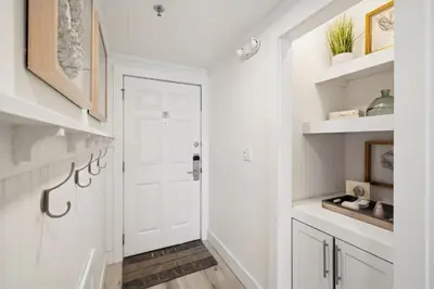 a hallway with a white door and white shelves at HP 24W Condo by 30A Escapes in Rosemary Beach