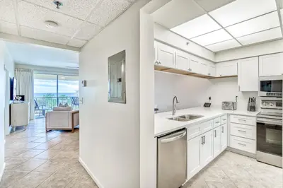 a kitchen with white cabinets and a view of the ocean at HP 422 Blue Haven by 30A Escapes in Rosemary Beach
